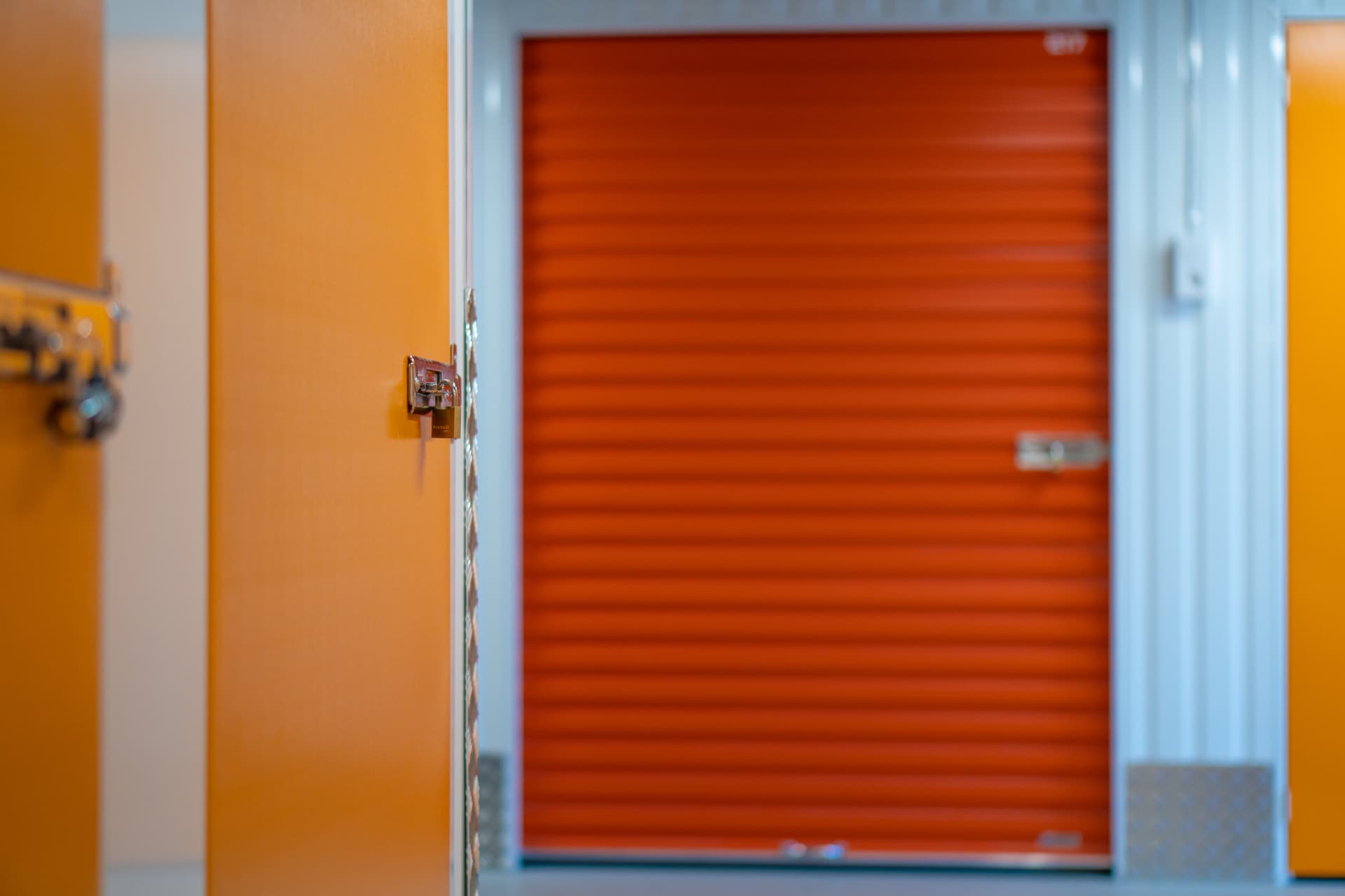 Orange förrådsdörr med hänglås på Porsön